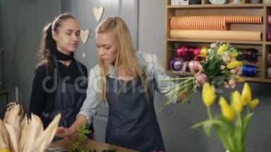 一个金发的<strong>花店</strong>老板和她的同事围着围裙在<strong>花店</strong>的柜台前，一边数着花束的价格